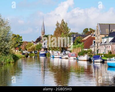 Canal de Wargaastervaart avec bateaux dans le village de Wergea, Leeuwarden, Frise, pays-Bas Banque D'Images