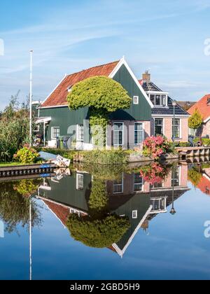 Maison traditionnelle en bois se reflétant dans le canal dans le village de Wergea, Leeuwarden, Frise, pays-Bas Banque D'Images