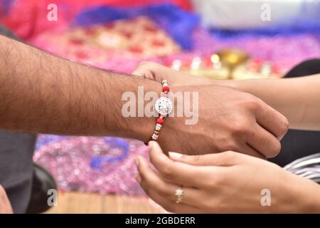 Gros plan de la sœur attachant rakhi au poignet de son frère, Raksha Bandhan Banque D'Images