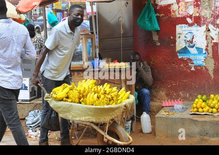 Isaac Musalwa qui a abandonné l'école en raison des frais d'école vend des bananes douces sur une meule porte à porte. Selon les directives du gouvernement en Ouganda, les gens sont invités à manger beaucoup de fruits. Ouganda. Banque D'Images