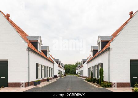 Maisons blanches modernes avec un toit orange à Thorn, Limbourg, pays-Bas, un village connu pour ses maisons blanches et ses bâtiments. Rue symétrique avec Banque D'Images