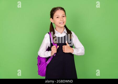 Photo portrait écolière avec sac à dos montrant un fond de couleur vert pastel isolé. Banque D'Images