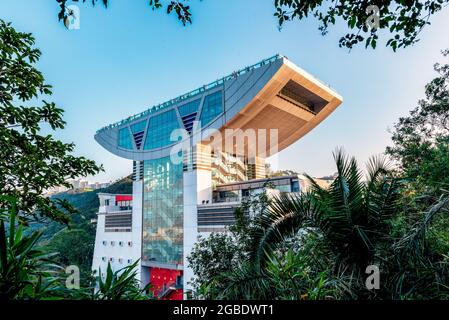 HONG KONG, HONG KONG - 24 juillet 2018 : une vue sur le bâtiment Peak depuis la piste de randonnée à travers les arbres... Banque D'Images