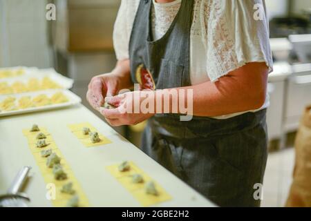 PIACENZA, ITALIE - 17 juillet 2021 : une cuisinière féminine préparant Tortelli - pâtes italiennes fourrées traditionnelles à Piacenza, Italie Banque D'Images