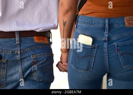 Un couple portant le pantalon Levi's en denim marche tenant les mains à Santa Fe, Nouveau-Mexique. Banque D'Images