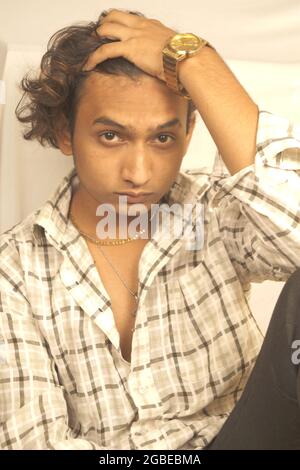 Plan vertical d'un jeune homme indien assis avec un triste visage mélancolique Banque D'Images