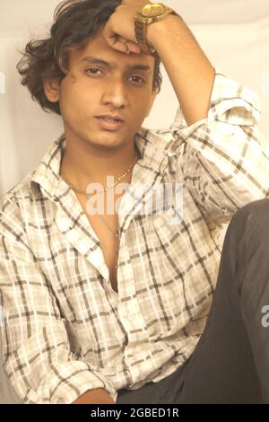 Plan vertical d'un jeune homme indien assis avec un triste visage mélancolique Banque D'Images