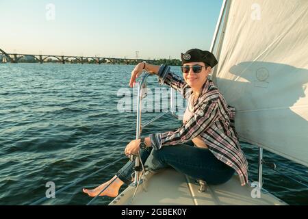 Un luxueux yacht vacances. Bonne belle femme d'âge moyen dans des lunettes de soleil sur le pont de bateau flotte sur la rivière. Banque D'Images