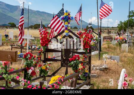 Cerro, Nouveau-Mexique - UN cimetière rural où les tombes sont décorées de fleurs et de drapeaux. Banque D'Images