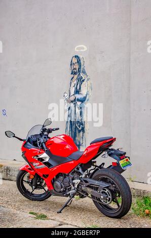 Une moto Ninja Kawasaki est garée à côté de l'art de la rue avec le Big Lebowski, le 1er août 2021, à Mobile, Alabama. Banque D'Images