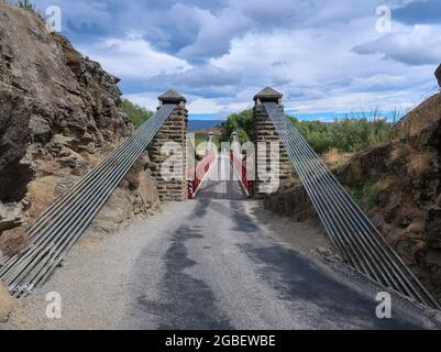 Le pont suspendu d'Ophir est un pont rouge classique à sens unique construit pendant la ruée vers l'or de l'Otago central, dans l'île du Sud, en Nouvelle-Zélande Banque D'Images