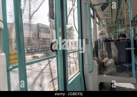 Karakoy, Istanbul, Turquie - 02.26.2021: Le vieil homme turc avec masque de corona est assis dans le tram tout en se déplaçant à vitesse rapide dans les temps de quarantaine tram intérieur et Banque D'Images