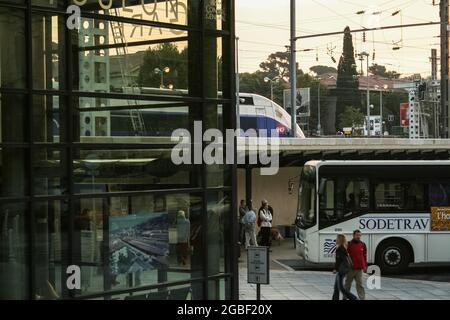 Photo de la gare routière et ferroviaire de Toulon en début de matinée avec les passagers prêts à monter à bord d'un bus avec un train SNCF en arrière-plan. Toulon est un c Banque D'Images