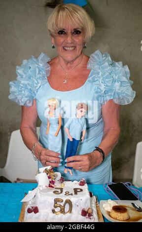 Femme âgée enjouée dans une robe festive célébrant le 50ème anniversaire de mariage Banque D'Images