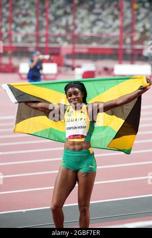 3 août 2021; Stade Olympique, Tokyo, Japon: Tokyo 2020 Jeux Olympiques d'été jour 11; Womens 200m final; THOMPSON-HERAH Elaine de la Jamaïque avec drapeau national comme elle gagne la course et la médaille d'or Banque D'Images