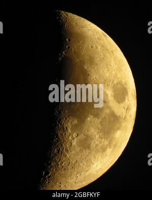 Plan vertical de la lune partiellement visible avec cratères sur fond noir Banque D'Images