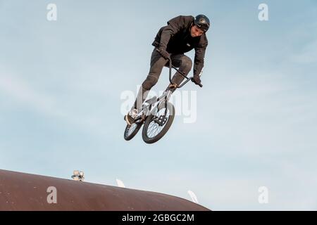 Kazan, Russie - 26 septembre 2020 : un jeune pilote sur un vélo BMX fait des tours dans les airs. Nage libre BMX dans un parc de skate. Banque D'Images