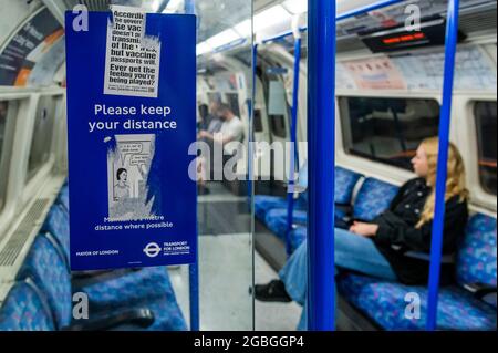 Londres, Royaume-Uni. 3 août 2021. Les signes sur le tube sont défacés par des anti-vaxers - la confusion de masque continue sur le souterrain après le dernier assouplissement. Le tube est plus occupé et les masques sont toujours obligatoires, mais de plus en plus de nombres ignorent l'instruction menée par des messages mixtes du gouvernement. Crédit : Guy Bell/Alay Live News Banque D'Images