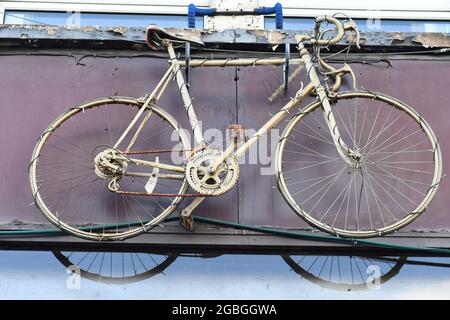 Un vieux vélo sur le devant de la boutique d'un magasin de vélos Banque D'Images