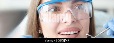 Portrait d'une jeune femme portant des lunettes de sécurité sur rendez-vous chez un dentiste Banque D'Images
