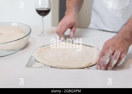 Gros plan de la cuisine masculine mains farines préparer une pâte, processus de fabrication de pizza Banque D'Images