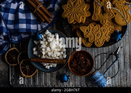 Vue en hauteur des biscuits de Noël en pain d'épice assortis, des guimauves miniatures et des épices Banque D'Images