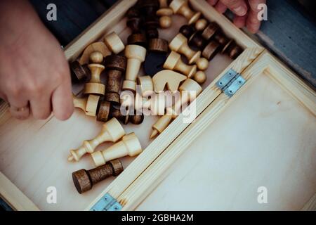 Gros plan des pièces d'échecs et des mains de la femme méconnaissable. Une femme inconnue tient des figures d'échecs dans ses mains Banque D'Images