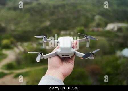 Petit quadriptère moderne et compact dans la main d'un homme. Lancer un drone de votre main Banque D'Images