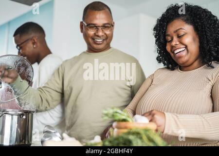 Bonne cuisine familiale noire à l'intérieur de la cuisine à la maison - Focus sur le visage de fille Banque D'Images