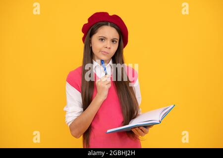 penser jeune fille d'école en béret français faire des notes dans le bloc-notes ou le bloc-notes de planificateur, septembre Banque D'Images