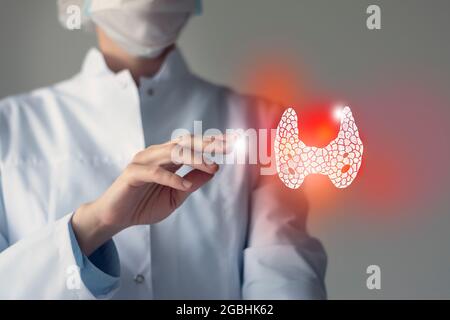 Le médecin féminin touche la glande thyroïde virtuelle dans la main. Photo floue, organe humain de la main, surligné en rouge comme symbole de la maladie. Hôpital de soins de santé se Banque D'Images