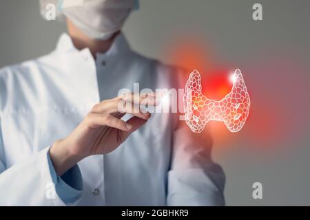 Le médecin féminin touche la glande thyroïde virtuelle dans la main. Photo floue, organe humain de la main, surligné en rouge comme symbole de la maladie. Hôpital de soins de santé se Banque D'Images