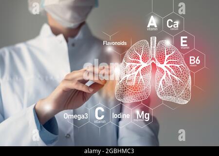 Nutriments essentiels pour la santé des poumons, y compris les oméga-3, les flavonoïdes, le magnésium, l'iode.Portrait flou du médecin tenant les poumons rouges mis en évidence. Banque D'Images