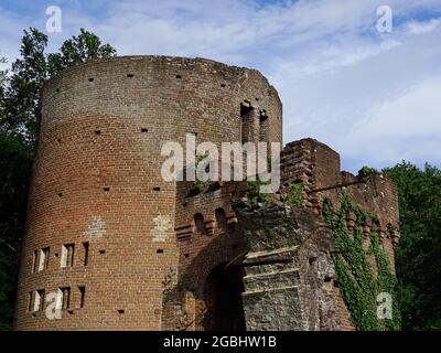 Une folie (fausse ruine) avec un ivy contre les vieux murs, de l'herbe au premier plan et un ciel bleu avec des nuages Banque D'Images