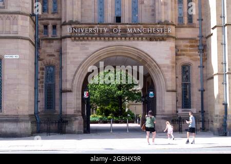 Femme et enfants regardent Whitworth Hall avec un panneau pour l'Université de Manchester, Manchester, Angleterre, Royaume-Uni. Banque D'Images