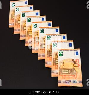 Ligne diagonale des billets en euros isolés sur fond noir, salaire en euros. Nouveau Banque D'Images