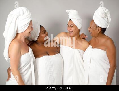 Femmes multiraciales s'amusant avec des serviettes avant maquillage de beauté - Focus sur les visages des femmes du centre-ville Banque D'Images