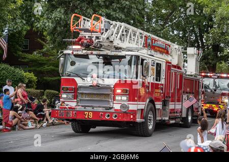 Wyomissing, Pennsylvanie, le 4 juillet 2021 : les familles regardent la parade annuelle du jour de l'indépendance avec des camions de pompiers Banque D'Images