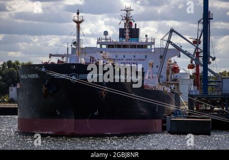 Rostock, Allemagne. 04e août 2021. Le pétrolier Harald Maersk étant manipulé au port maritime. Le port maritime de Rostock a fermé le premier semestre 2021 avec un débit record. De janvier à fin juin, 14.4 millions de tonnes ont traversé le quai. Credit: Jens Büttner/dpa-Zentralbild/dpa/Alay Live News Banque D'Images