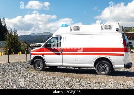 Vue latérale d'une ambulance blanche de secours ems voiture garée près de la campagne route rurale dans la région de la station de montagne de Highland. Service de premiers soins paramédic Banque D'Images