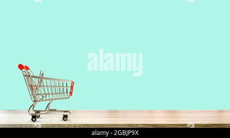 Chariot de supermarché sur un fond de couleur pure. Concept d'achat et de vente d'épicerie en ligne. Photo de haute qualité Banque D'Images