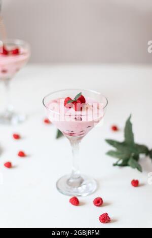 Dessert délicieux, cheesecake aux framboises fraîches et mousse au beurre sur une table blanche. Copier l'espace Banque D'Images