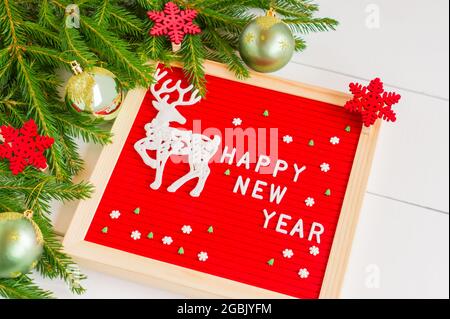 Flat Lay avec félicitations bonne année 2022 sur le tableau de lettres. Vue de dessus. Cadre festif avec branches de sapin et boules dorées. Message d'accueil ca Banque D'Images