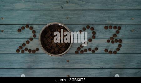 Nouveau an ou concept de Noël fond minimaliste avec les numéros 2023 de nourriture de chat ou de chien. Publicité créative d'un magasin d'animaux de compagnie. Languette en bois bleu Banque D'Images