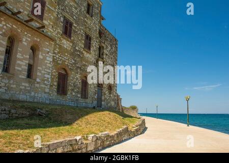 Un vieux bâtiment en pierre abandonné sur le chemin côtier de la ville côtière médiévale historique de Porec, en Istrie, Croatie Banque D'Images