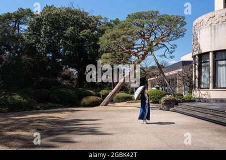 Tokyo, Japon. 14 mars 2021. Femme japonaise utilisant un parapluie pour faire face aux températures et à la chaleur élevées pendant les mois d'été dans la ville de Tokyo. Crédit : SOPA Images Limited/Alamy Live News Banque D'Images