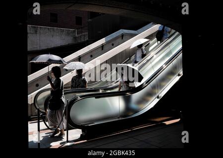 Tokyo, Japon. 20 juillet 2021. Les gens qui utilisent des parasols pour faire face aux températures et à la chaleur élevées pendant les mois d'été dans la ville de Tokyo. Crédit : SOPA Images Limited/Alamy Live News Banque D'Images