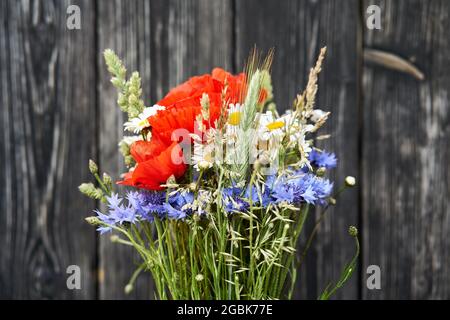 Bouquet bouquet fleurs sauvages camomille pavot cornflower seigle fond en bois Banque D'Images