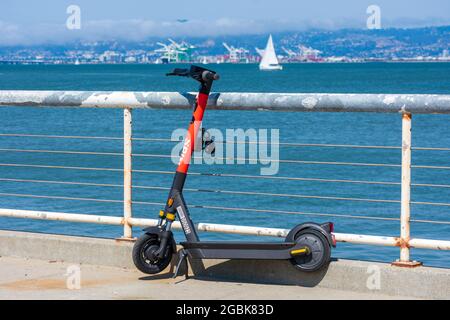 Scooter de spin électrique voyagement e-scooter S-100 garés sur le front de mer pittoresque. Spin est une société de partage de bicyclettes et de trottinettes appartenant à Ford Motor Banque D'Images