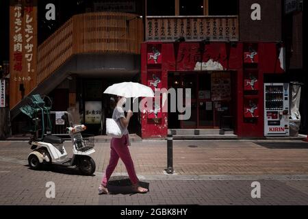 Tokyo, Japon. 10 juillet 2021. Une femme utilisant un parapluie pour faire face aux températures et à la chaleur élevées pendant les mois d'été dans la ville de Tokyo. (Photo de Tanja Houwerzijl/SOPA Images/Sipa USA) crédit: SIPA USA/Alay Live News Banque D'Images